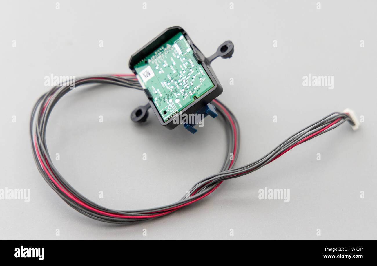 A small electronic module with wires and connector on grey background Stock Photo