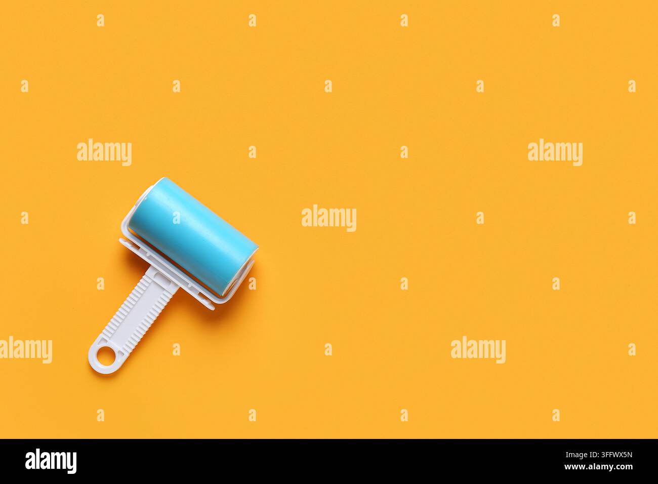 Lint roller on orange background Stock Photo