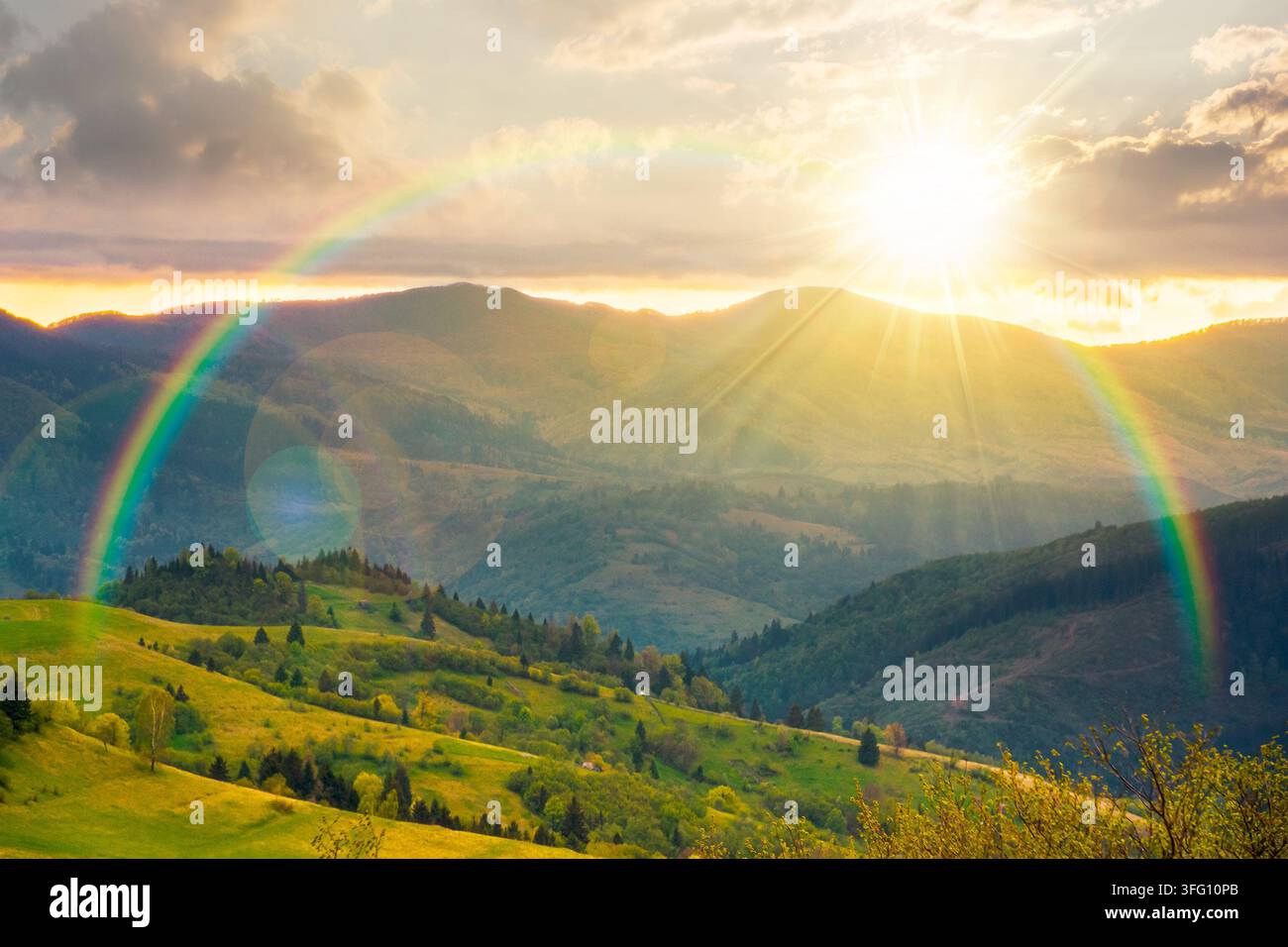 sunset over mountainous countryside scenery. cloudy sky view above the valley. green fields and trees on the hills. volatile nature scenery of carpath Stock Photo