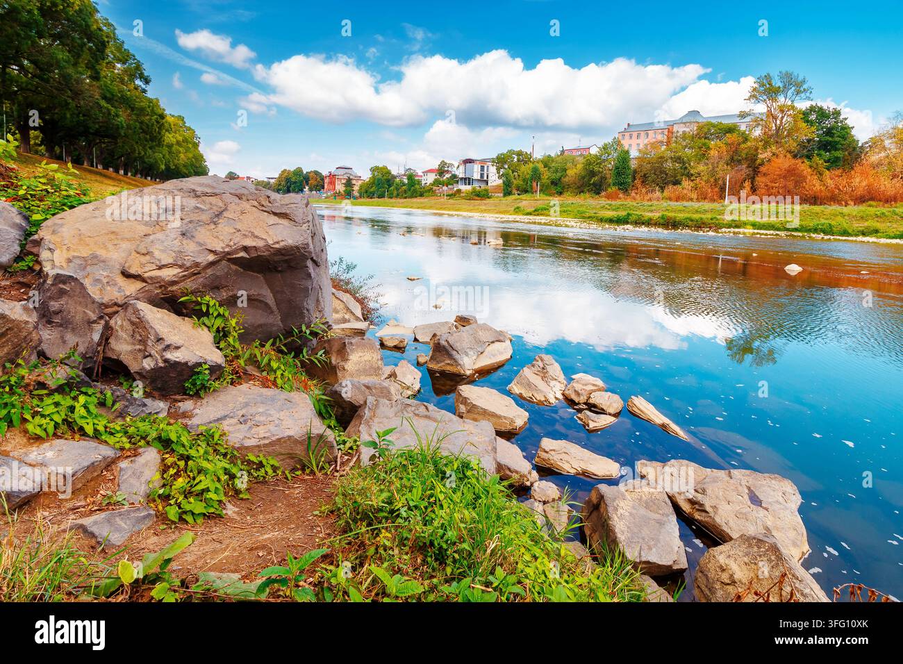 urban landscape with city park and a river in front. beautiful autumn scenery of Uzhhorod Orthodox embankment. vacation background with sky reflection Stock Photo
