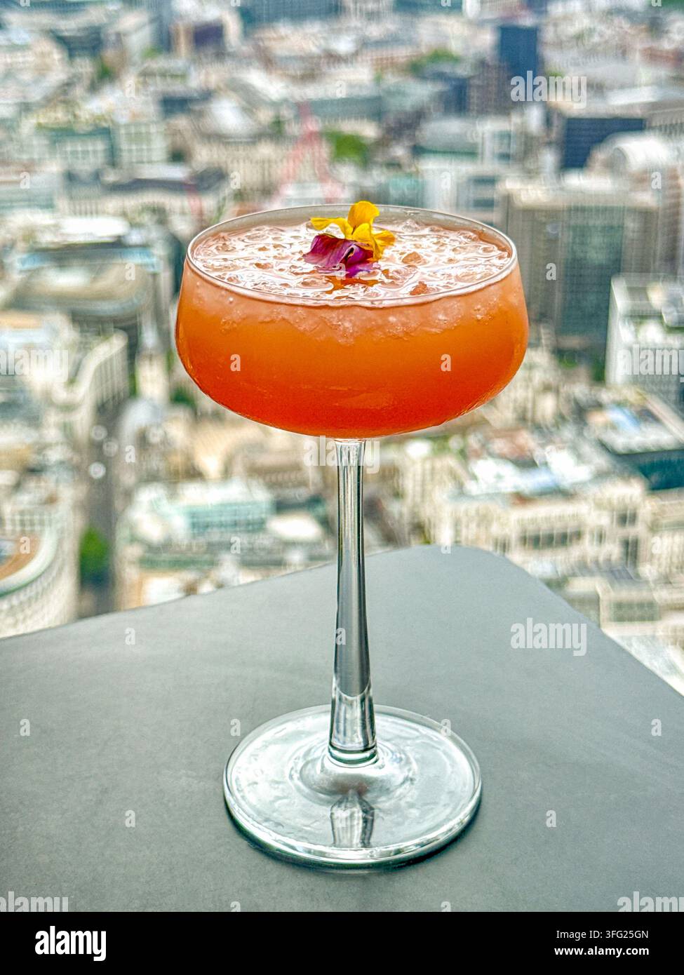 Colourful cocktail on the table of a restaurant at the top of a skyscraper in a city. No people. - Smartphone Captured Stock Image
