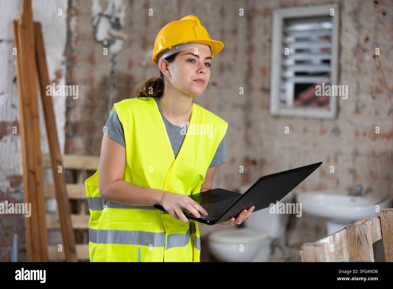 Female engineer using laptop in apartment Stock Photo