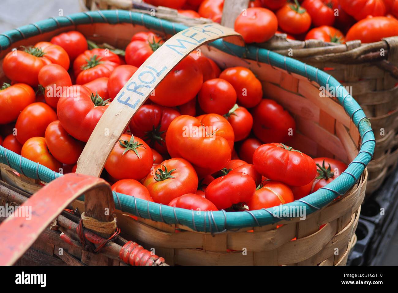 Fresh tomatoes in woven baskets at a market Stock Photo