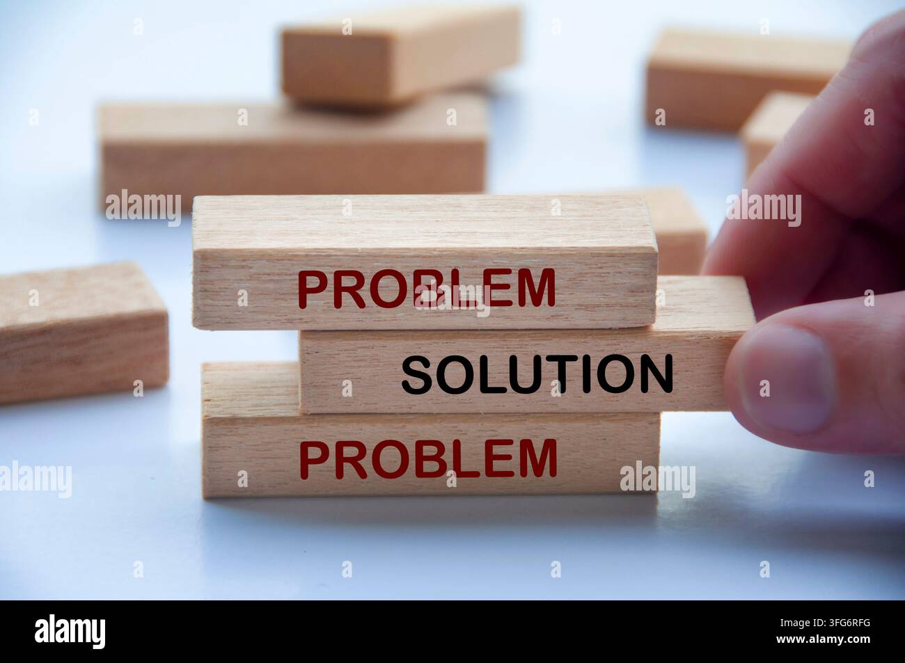 Hand holding wooden block representing a straightforward approach to resolving problems and finding solutions Stock Photo