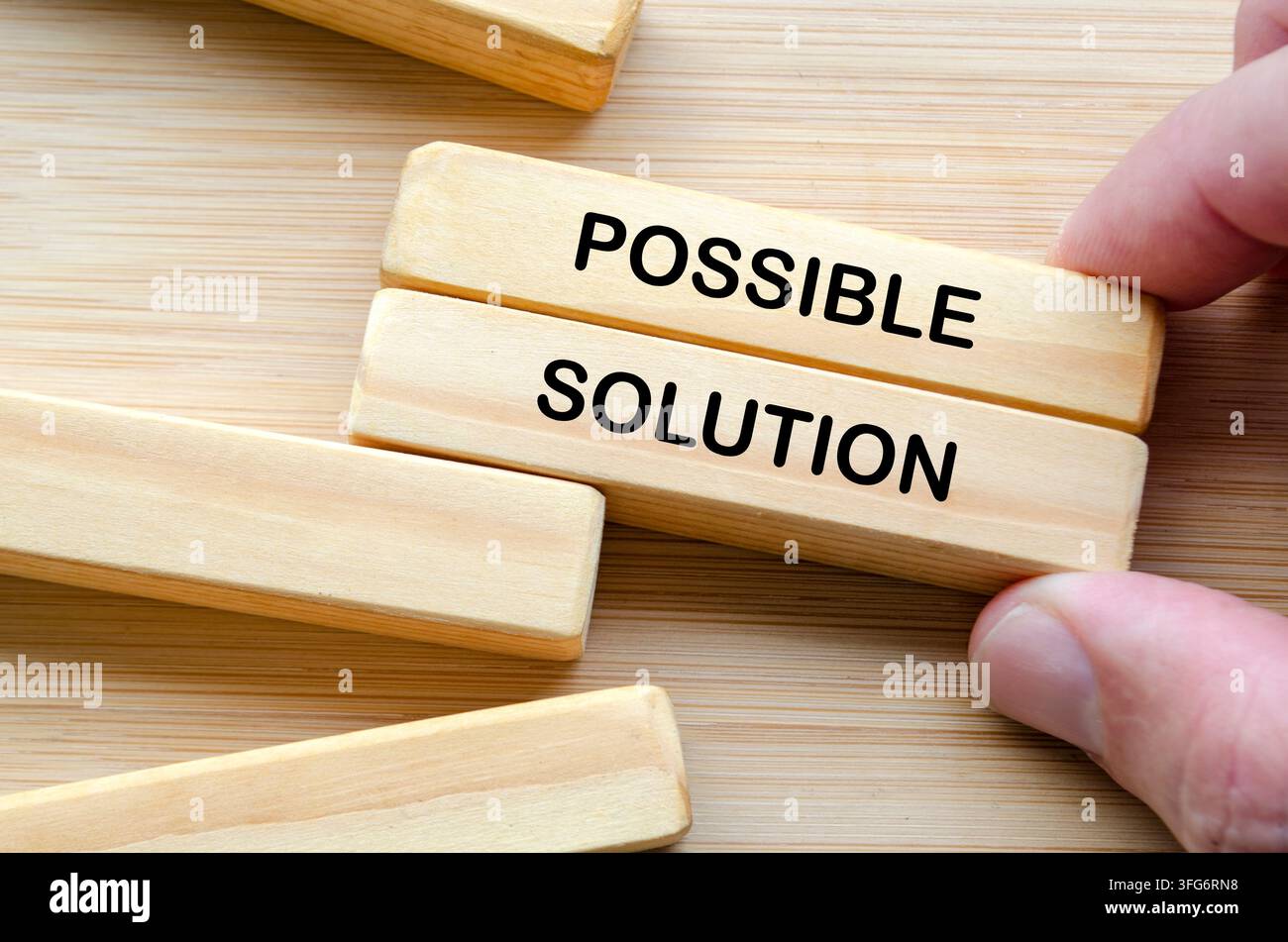 Hand holding wooden blocks representing structured problem solving with possible solution. Stock Photo