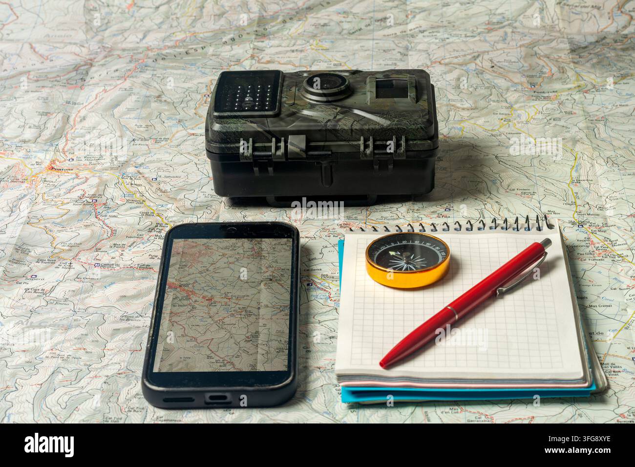 Planning wilderness adventure using map, compass, and digital devices Stock Photo