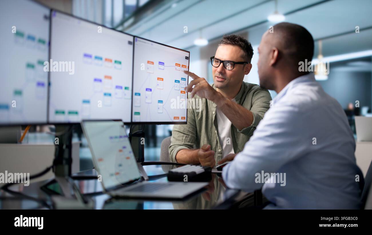 Business Analyst And Engineer Collaborate Optimizing Automated Workflow Efficiently. Stock Photo