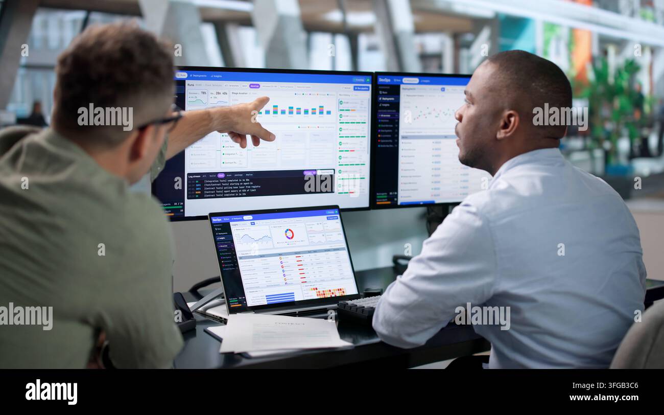 DevOps Engineer Monitors Pipeline Status On Laptop For Smooth Software Delivery. Stock Photo