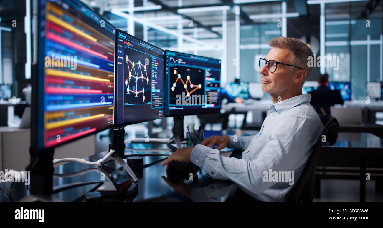 Senior Software Developer Pointing At Screen While Writing Efficient Code. Stock Photo