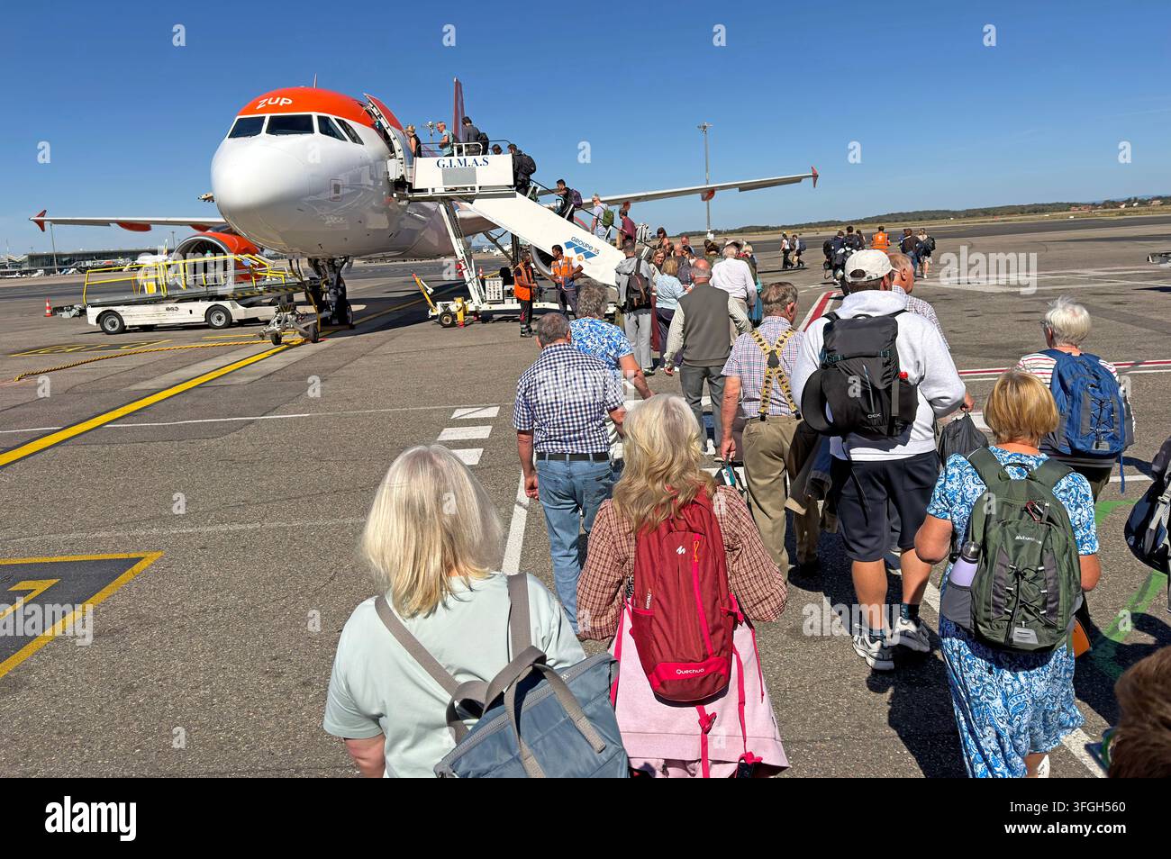 Passengers queue on the apron to board an easyJet Airbus A320 at Lyon Airport, France. Stock Photo