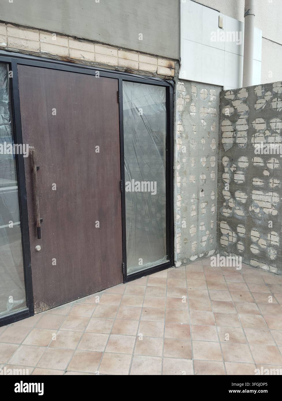 Building entrance with walls stripped back during renovation work in Tokyo, Japan. - Smartphone Captured Stock Image