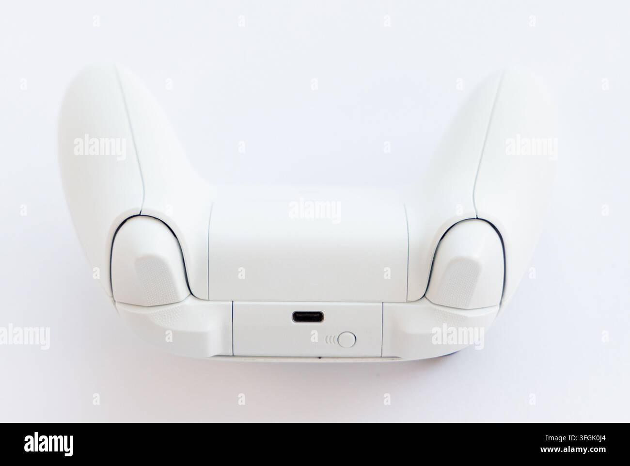 A white wireless game controller is shown from the back view Stock Photo