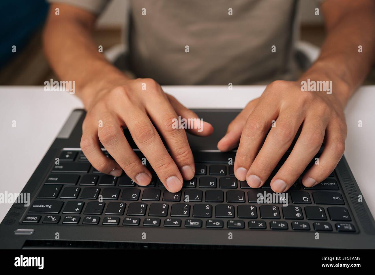 High-angle view of unrecognizable programmer male typing code on laptop keyboard, showcasing process of software development and coding expertise Stock Photo