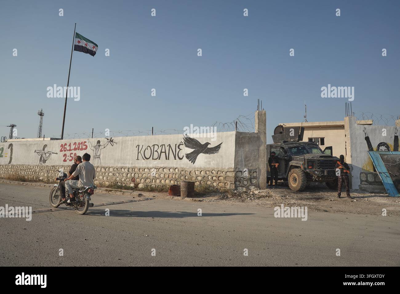 A Man Rides A Motorcycle Past A Post Of The Kurdish Internal Security 