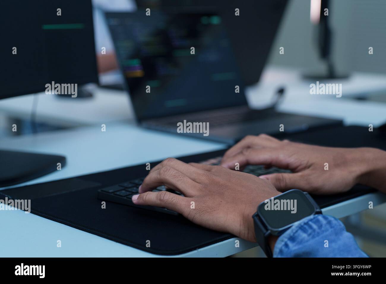 Developer hands typing on a laptop keyboard while working with digital code, software development, programming, and artificial intelligence technology Stock Photo