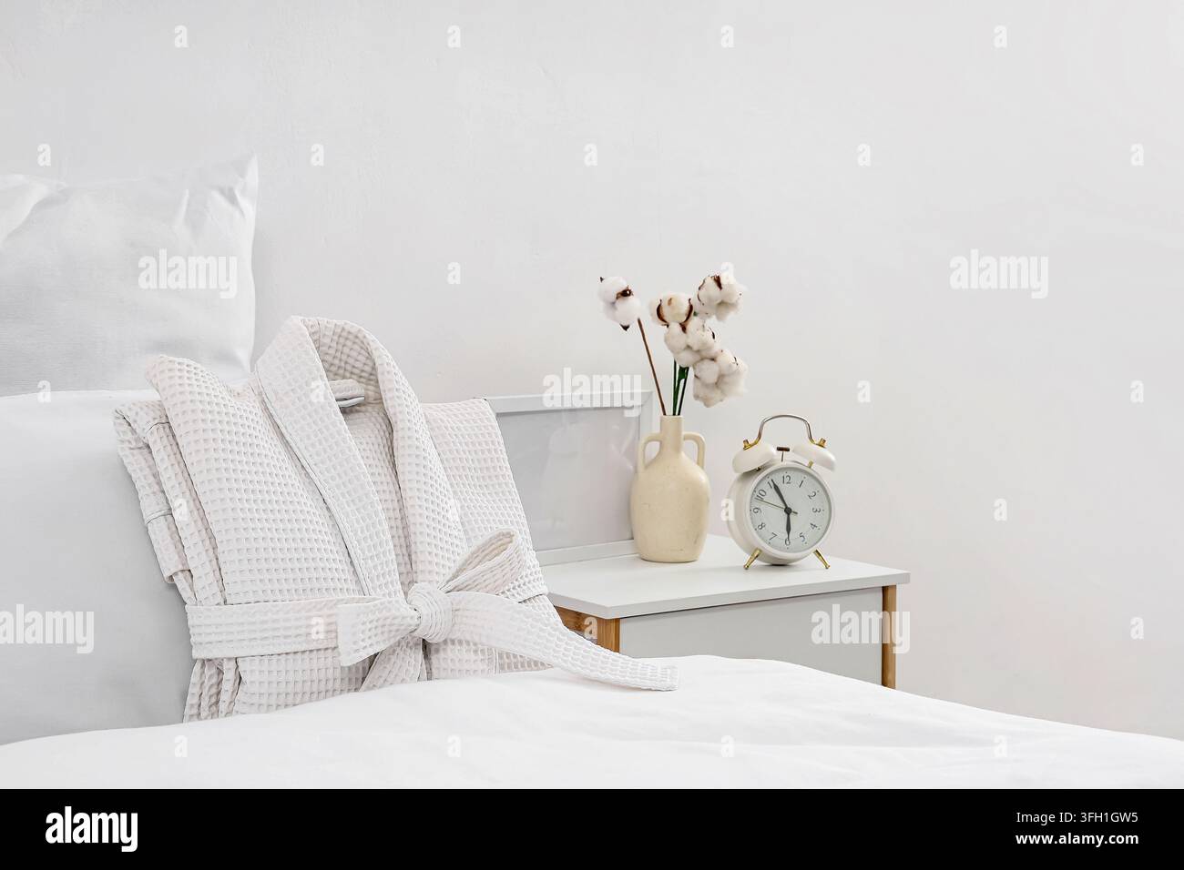 Folded waffle bathrobe on bed in room Stock Photo