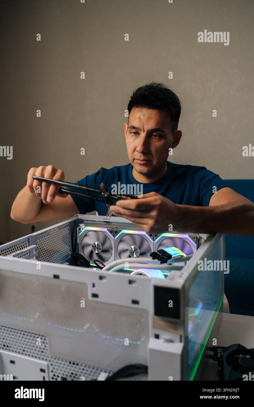 Vertical portrait of computer technician inserting wireless network module inside custom desktop computer, enhancing system connectivity for reliable Stock Photo