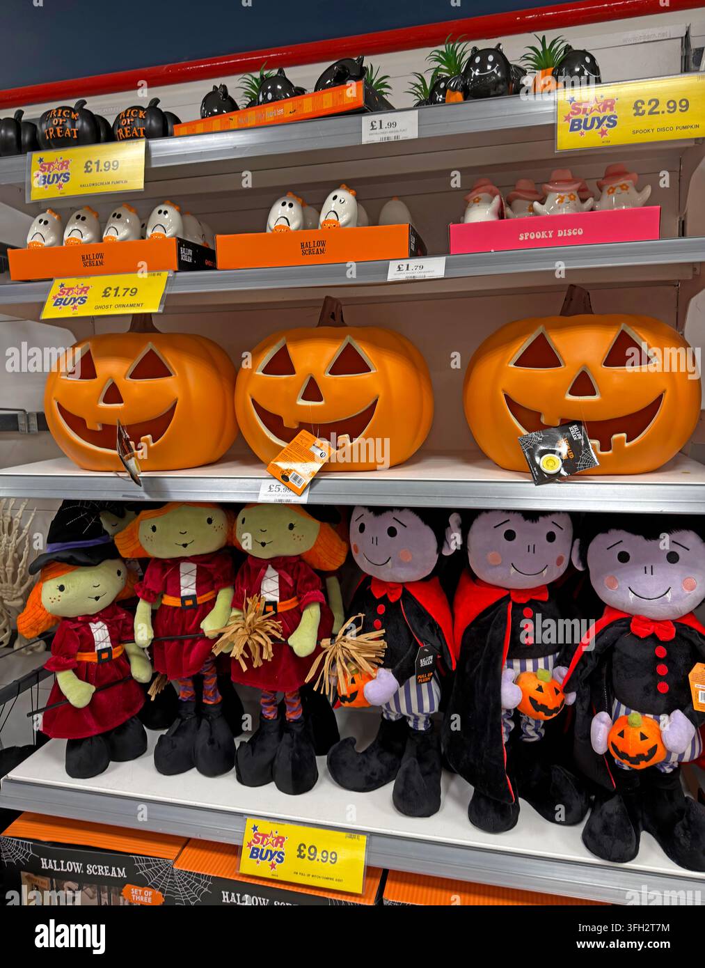 Halloween October merchandise and pumpkin decorations on a seasonal supermarket shelf under Star Buys promotional price labels. Stock Photo