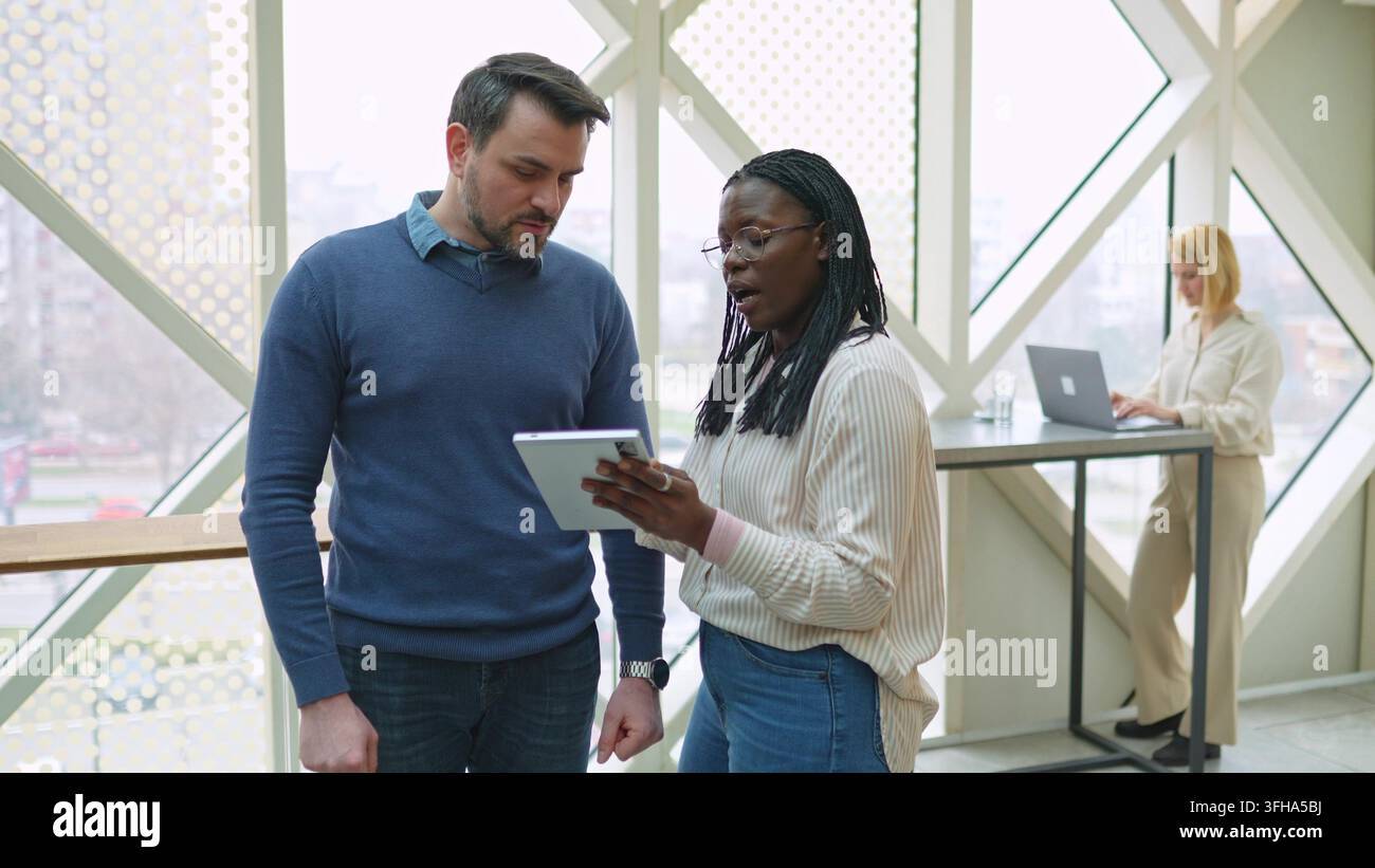 Diverse colleagues discussing a project on a digital tablet Stock Photo