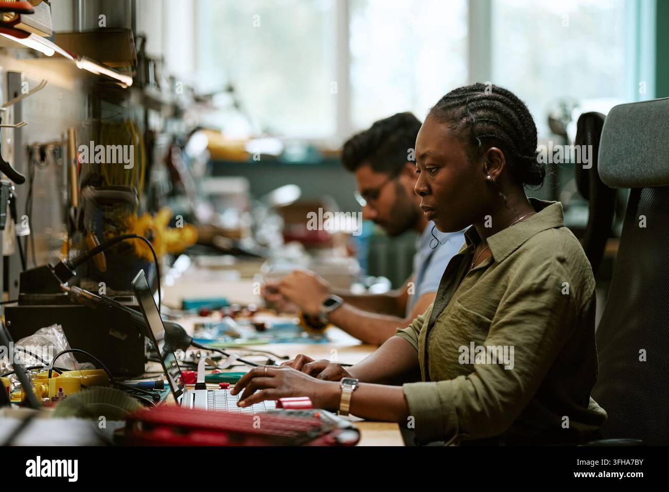 Black Woman Engineer Using Laptop in Electronics Laboratory Stock Photo
