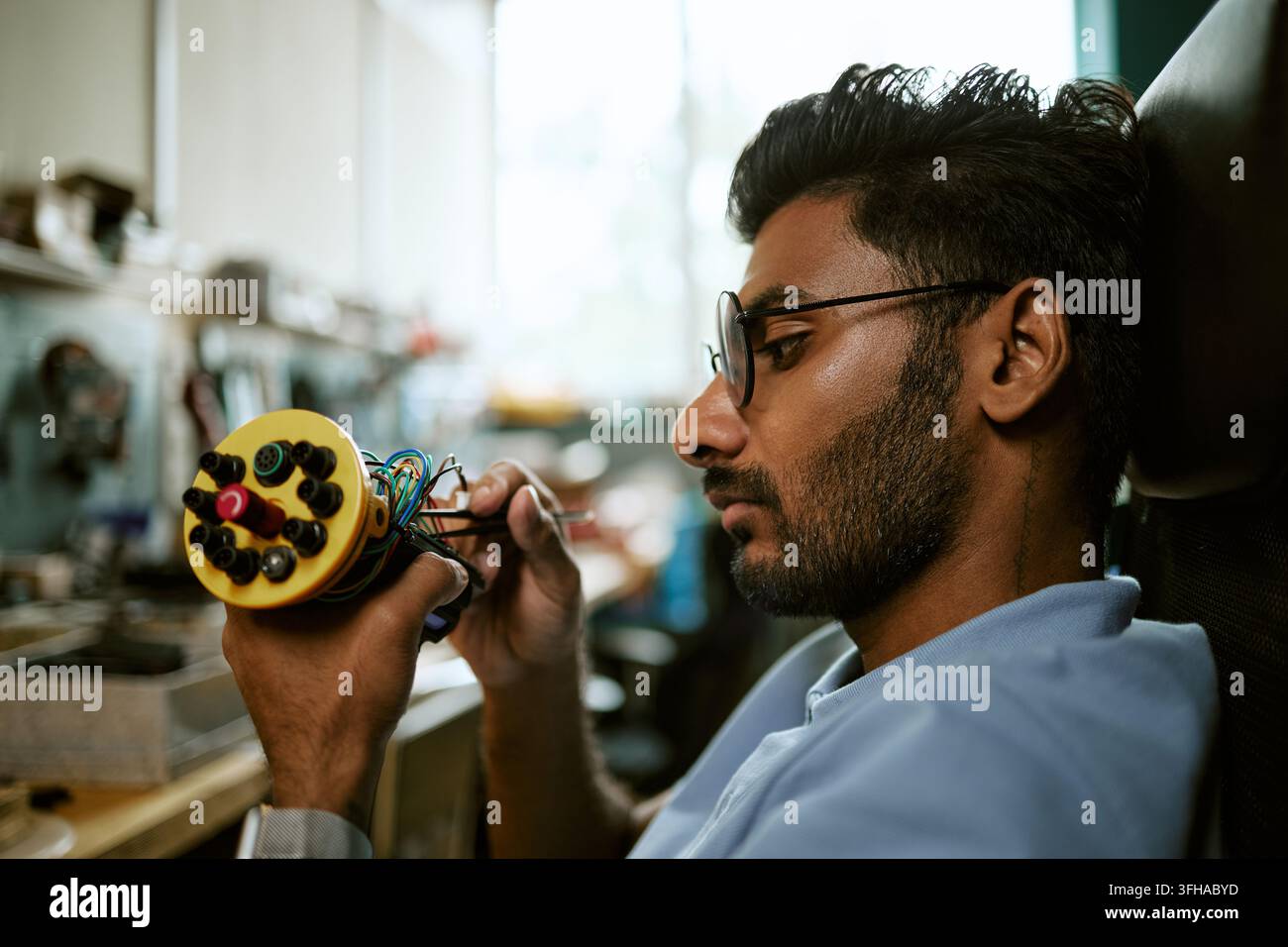 Indian Engineer Assembling Robotic Device in Tech Lab Stock Photo