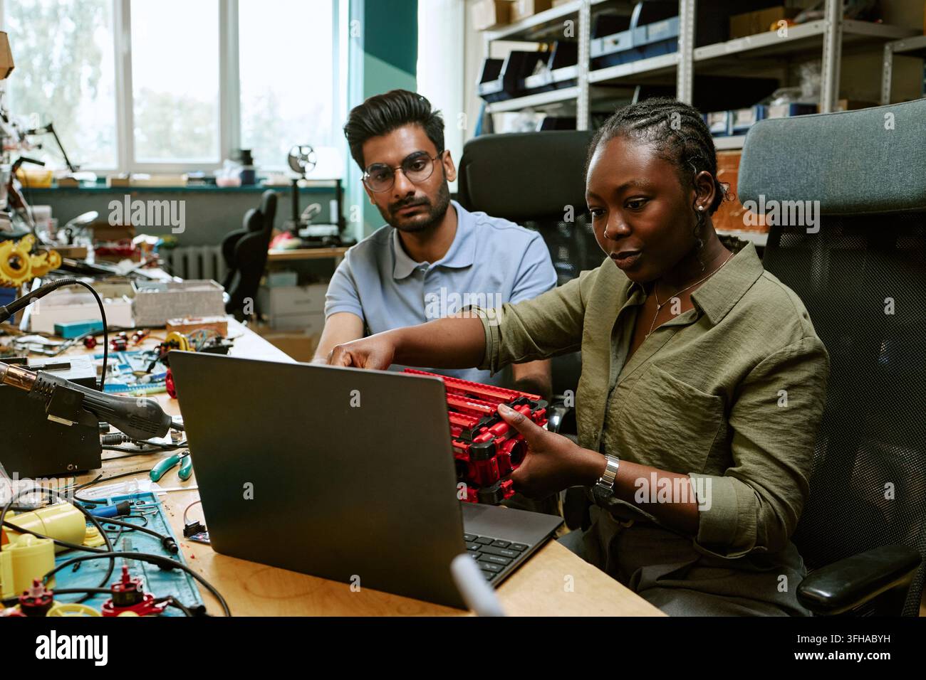 Multiethnic Engineers Developing Robotics Using Laptop in Workshop Stock Photo