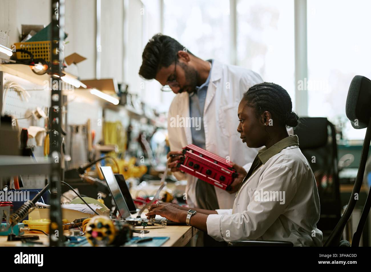 Diverse Engineers Developing Hardware Components in Modern Tech Laboratory Stock Photo