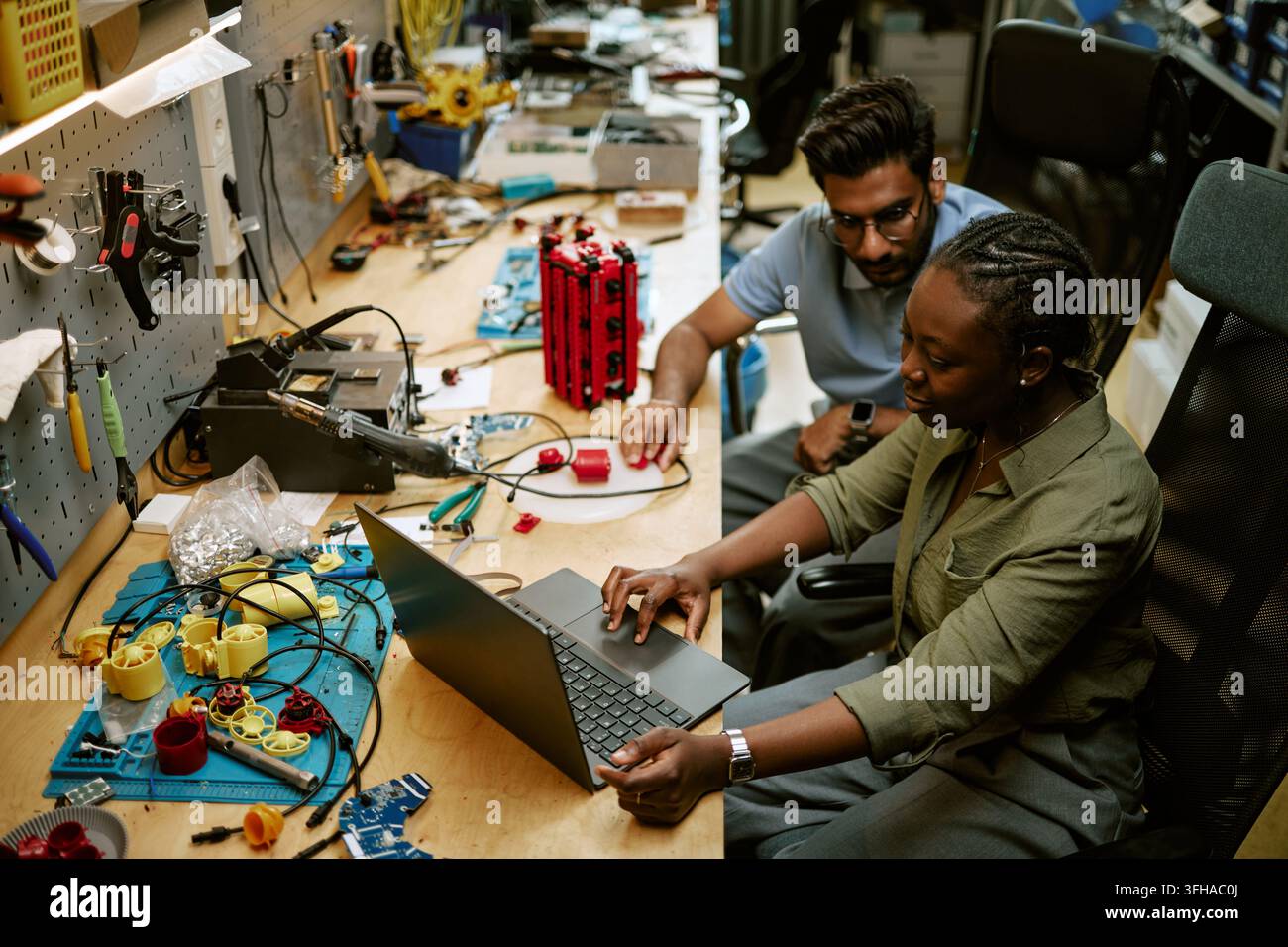 Diverse Engineers Developing Hardware Components on Laptop in Workshop Stock Photo