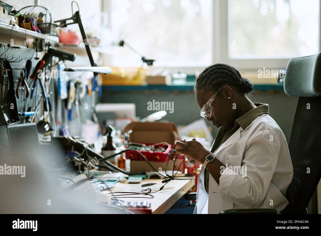 Black Woman Engineer Testing Electronic Components in Lab Stock Photo