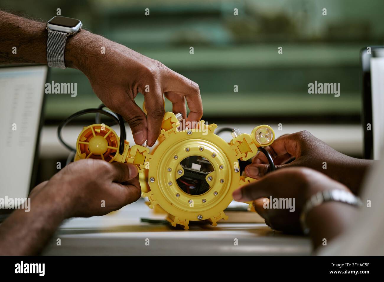 Black Engineers Assembling Yellow Underwater Drone in Laboratory Stock Photo