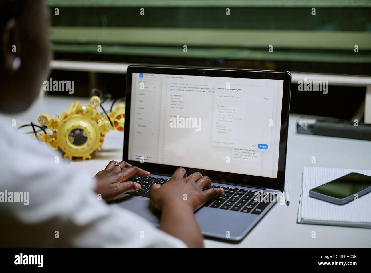 Black Woman Coding Software on Laptop for Robotics Project Stock Photo