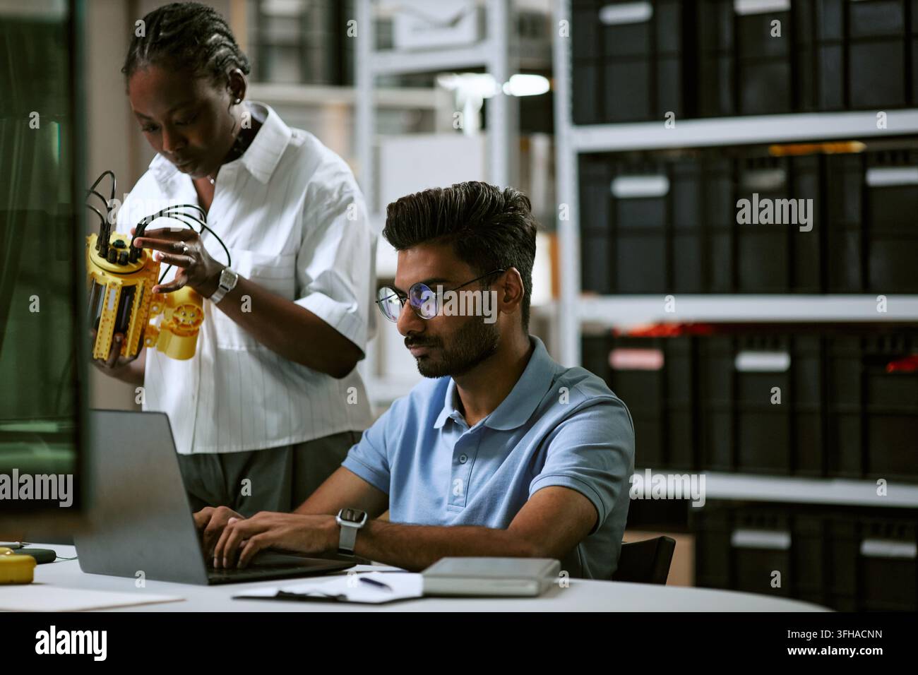 Diverse Engineers Developing Robotic Arm Prototype in Modern Laboratory Stock Photo
