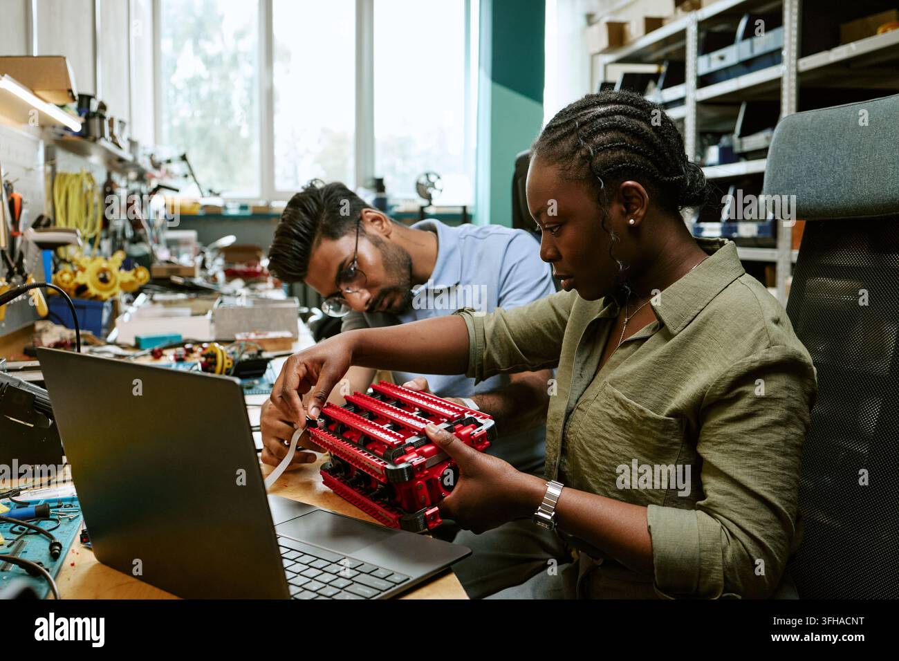 Multiethnic Engineers Assembling Robotic Prototype in Lab Stock Photo