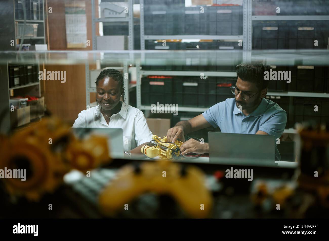 Diverse Engineers Working on Robotics Prototype with Laptops Stock Photo