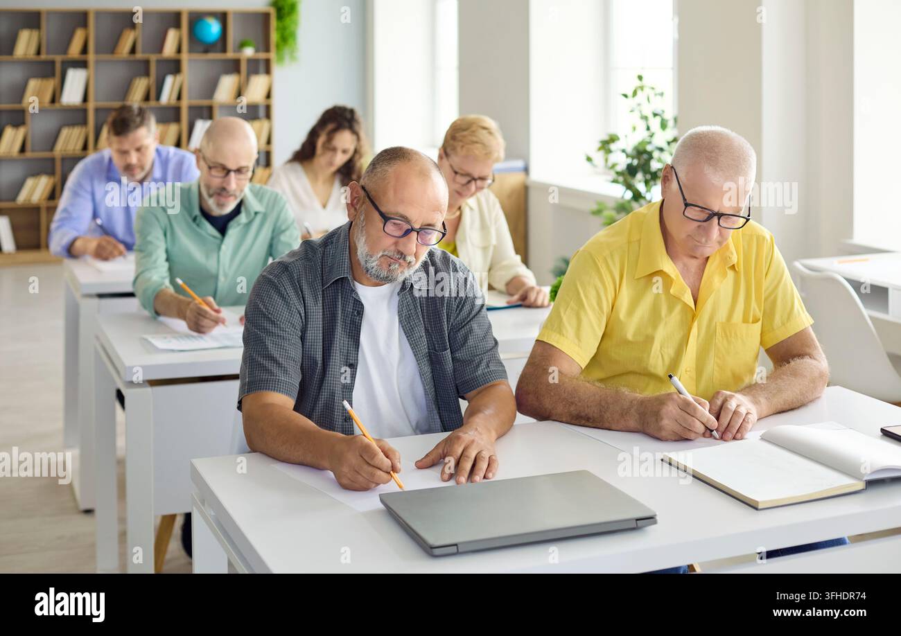 Adult students in classroom training, taking notes during computer learning course Stock Photo