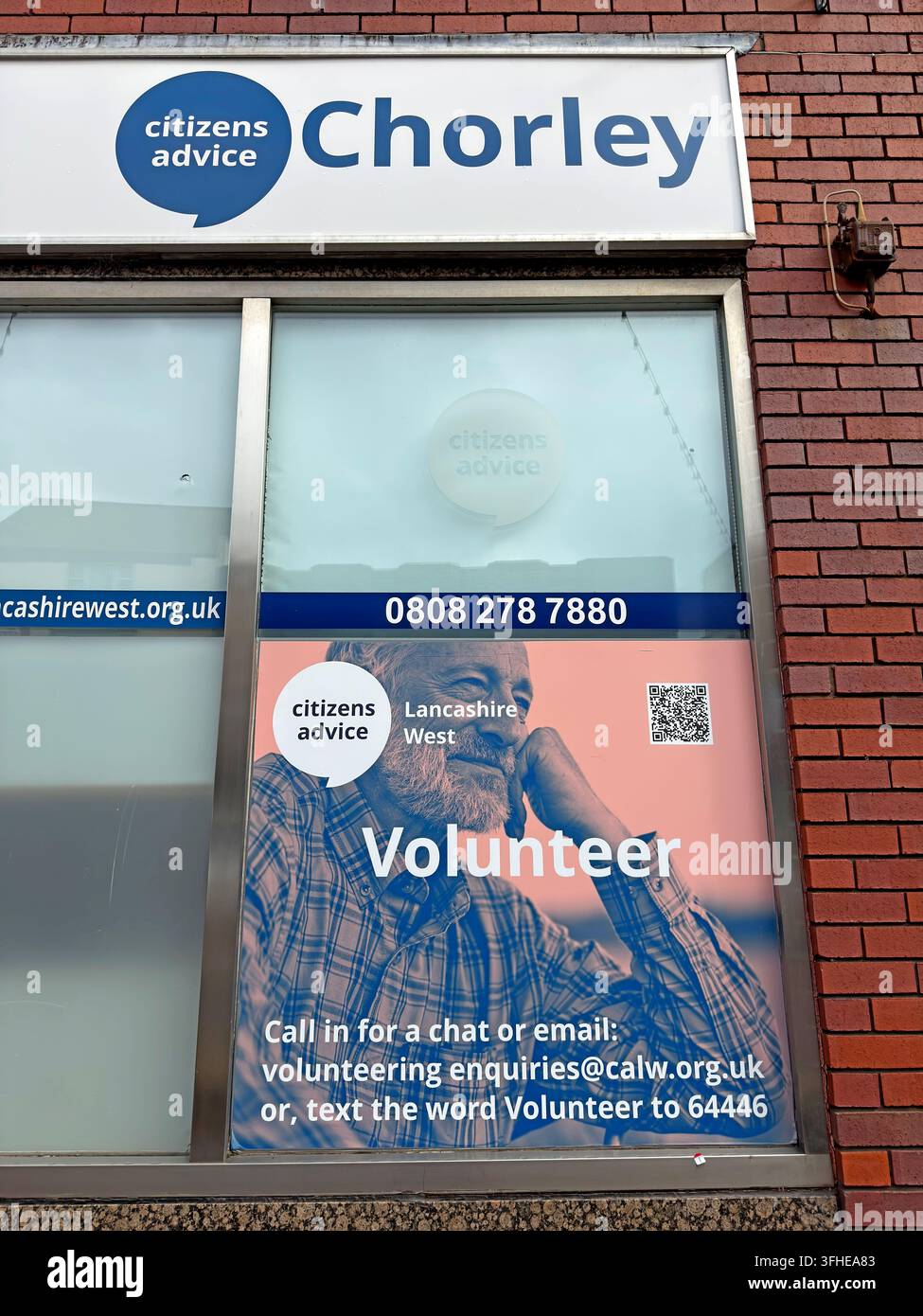Citizens Advice Lancashire West office in Chorley displays a volunteer recruitment message on Market Street. Stock Photo