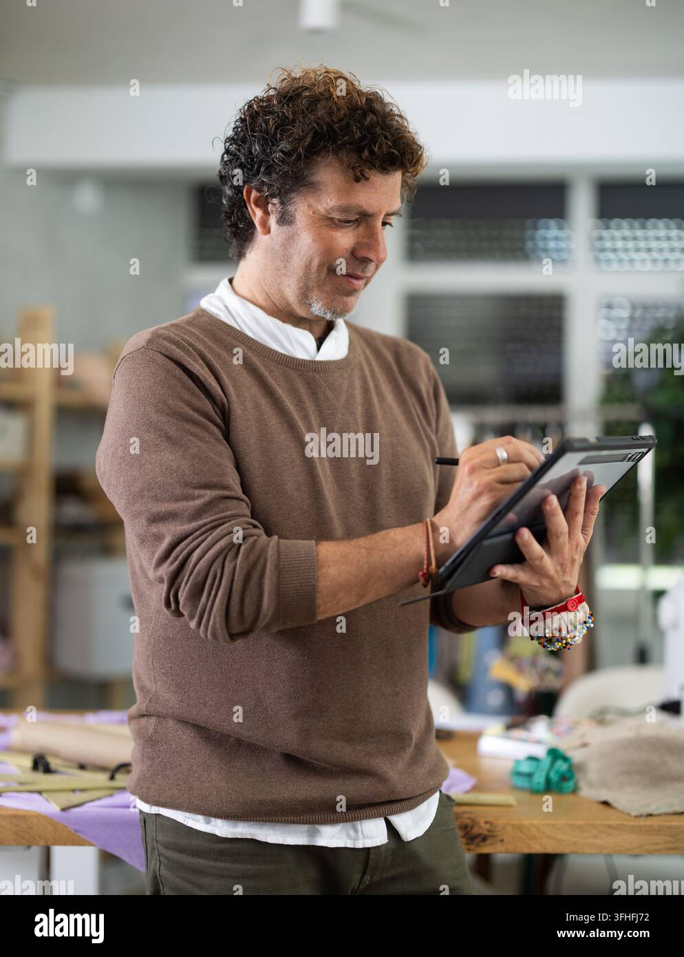 Man tailor makes pattern using tablet Stock Photo