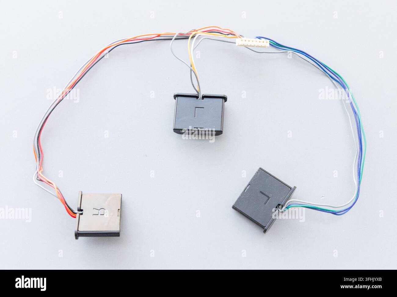 Electronic wires, modules, and a connector are arranged on a plain surface Stock Photo