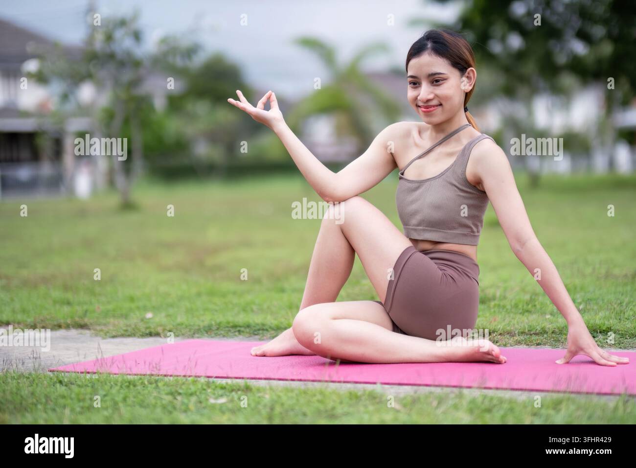 Young Woman Practicing Seated Yoga Pose on Mat Outdoors Stock Photo