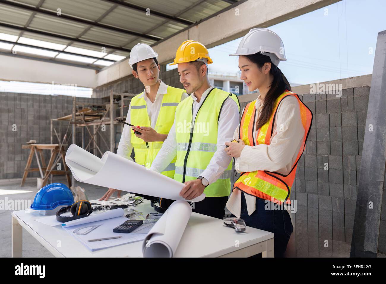 Engineers discussing construction blueprints on site, focusing on project execution and design implementation. Stock Photo
