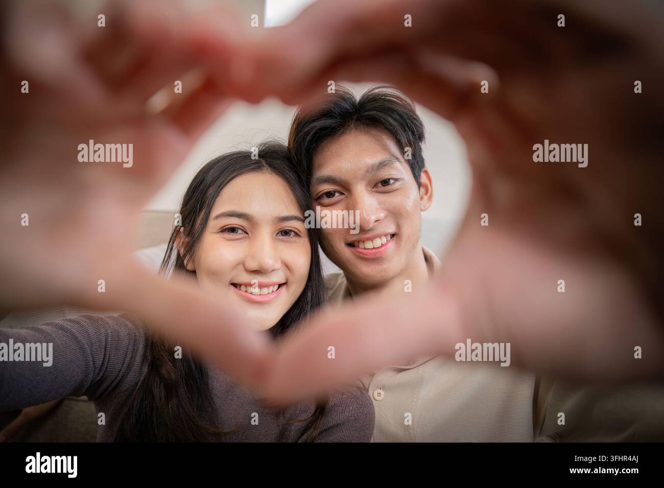 Young couple making a heart shape with their hands Stock Photo