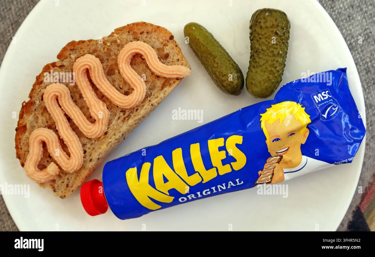 Kalles Original Swedish cod roe spread served on bread with butter and pickled gherkins on a plate. Stock Photo