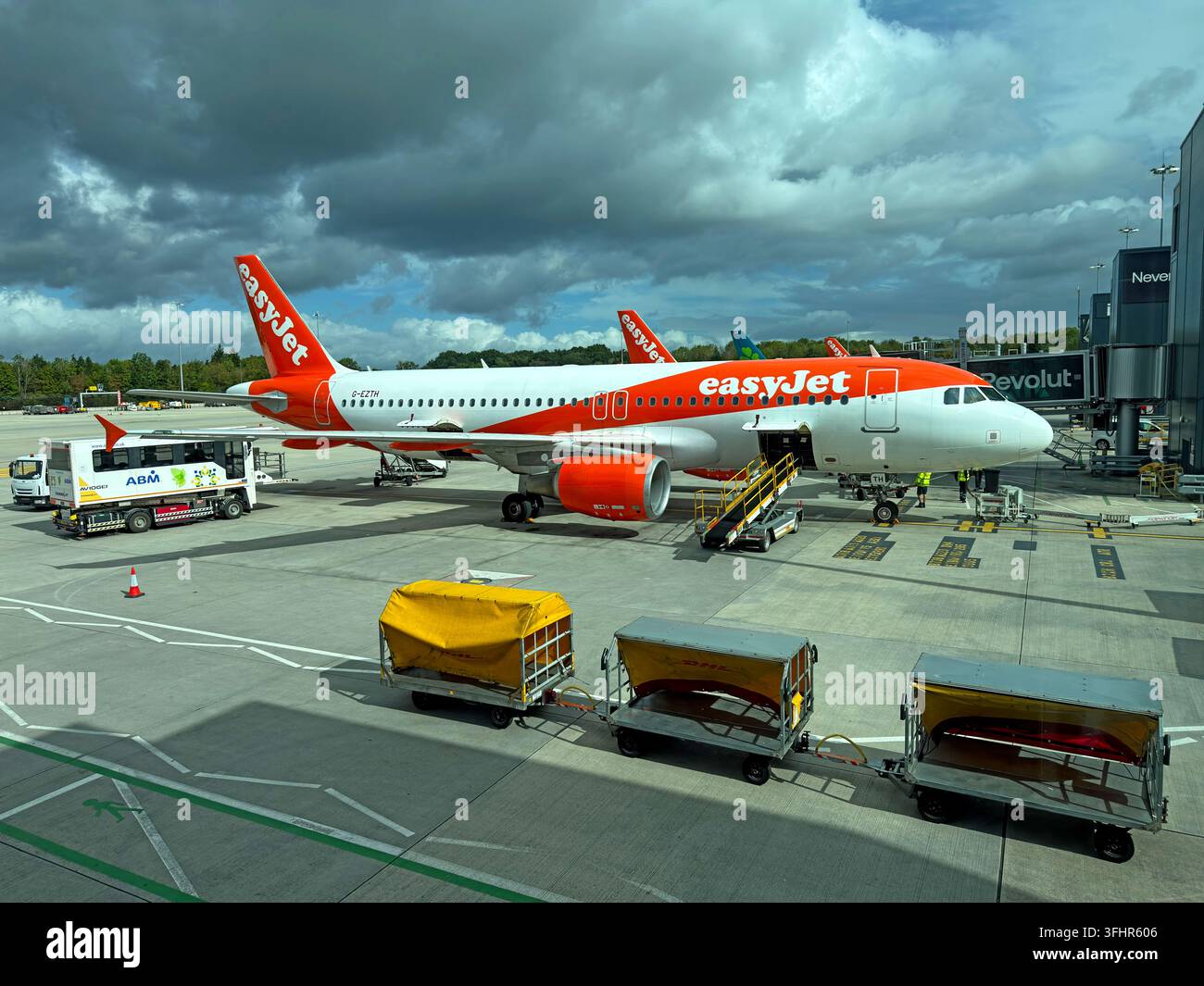 easyJet Airbus A320-214 G-EZTH parked on an airport apron with ground-service equipment during a turnaround. Stock Photo