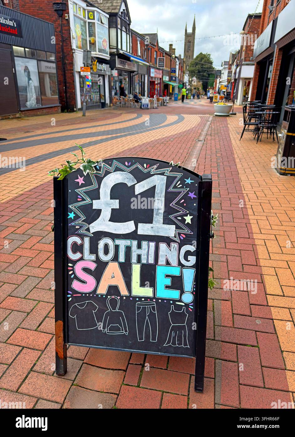 £1 clothing sale pavement sign outside a discount shop on Chapel Street, Chorley, Lancs. low-cost retail, betting, vape and charity shops shape town Stock Photo