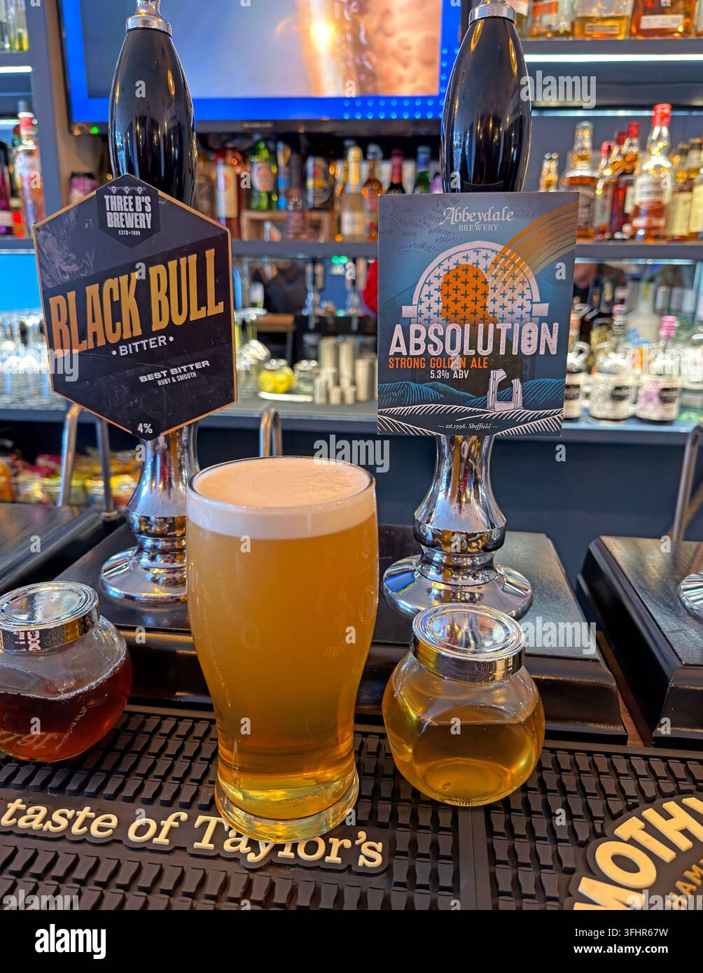 Pint of real ale beside Black Bull and Abbeydale Absolution handpulls at Inn the Dog House, Chorley, Lancashire. Stock Photo