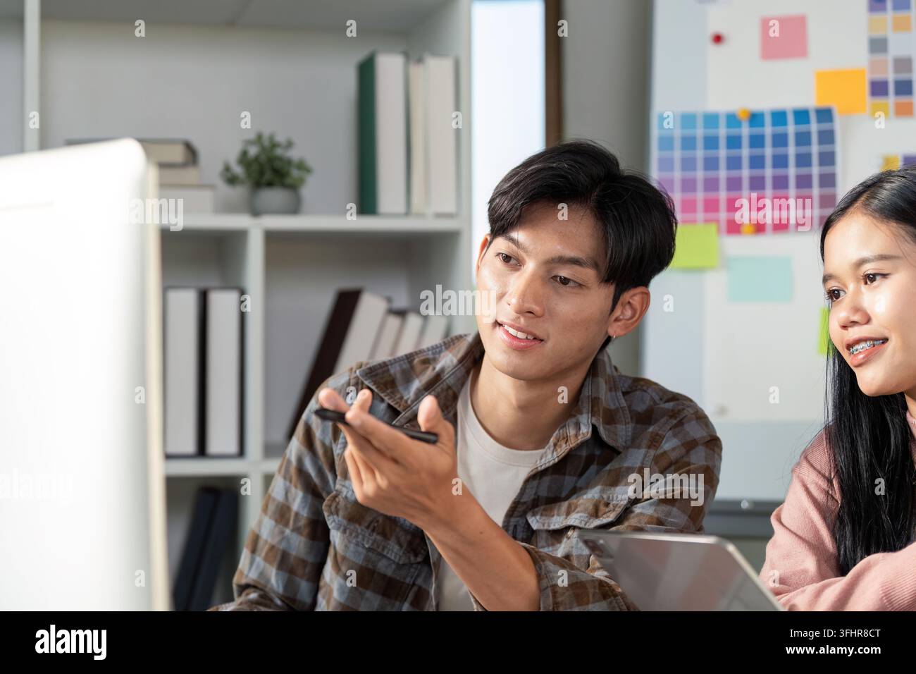 A design team collaborates on graphics showcasing creativity and teamwork in a modern office setting. Stock Photo