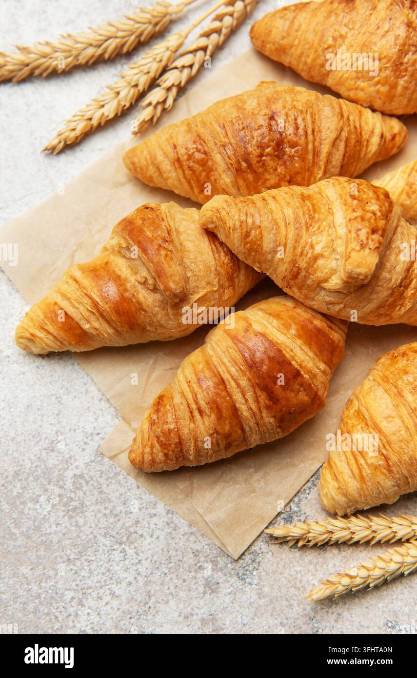 Freshly baked croissants with wheat on baking paper Stock Photo