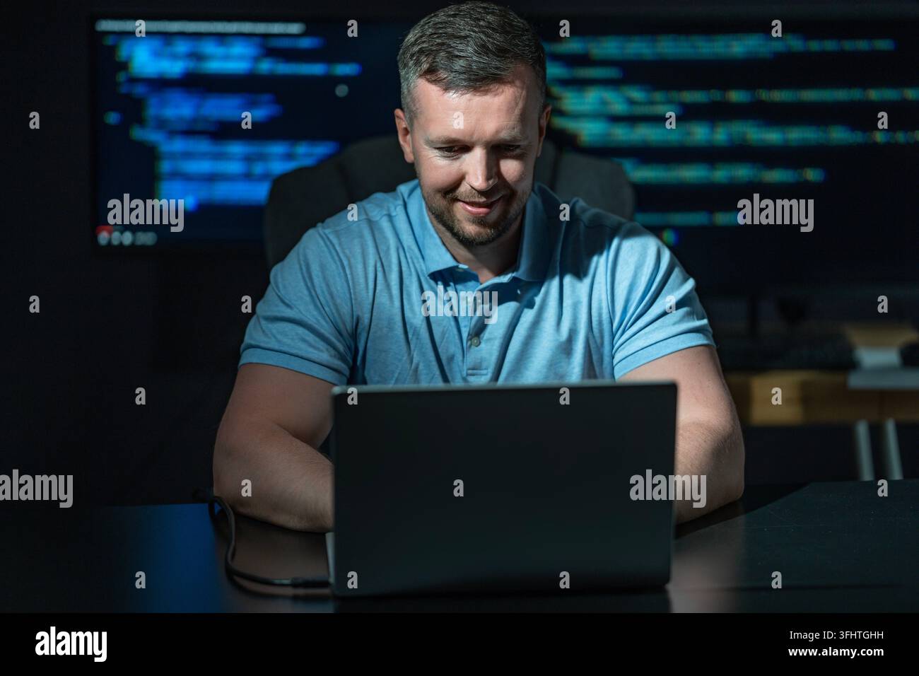 Hacker uses computer for cyber attack. Hacker writes malicious code on screen. Hacker monitors secure network activity. Hacker creates digital Stock Photo