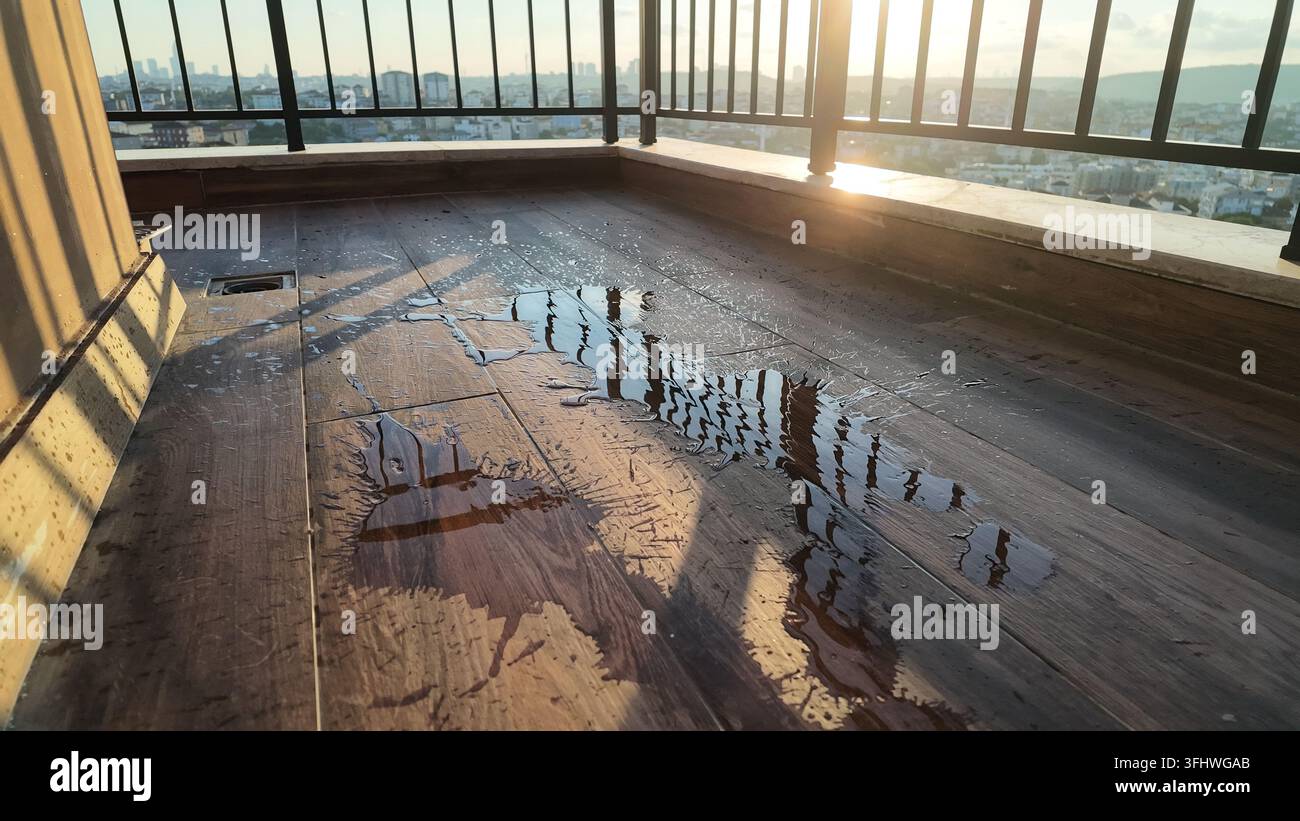 Water is on the wooden floor at sunset. The city can be seen in the ...