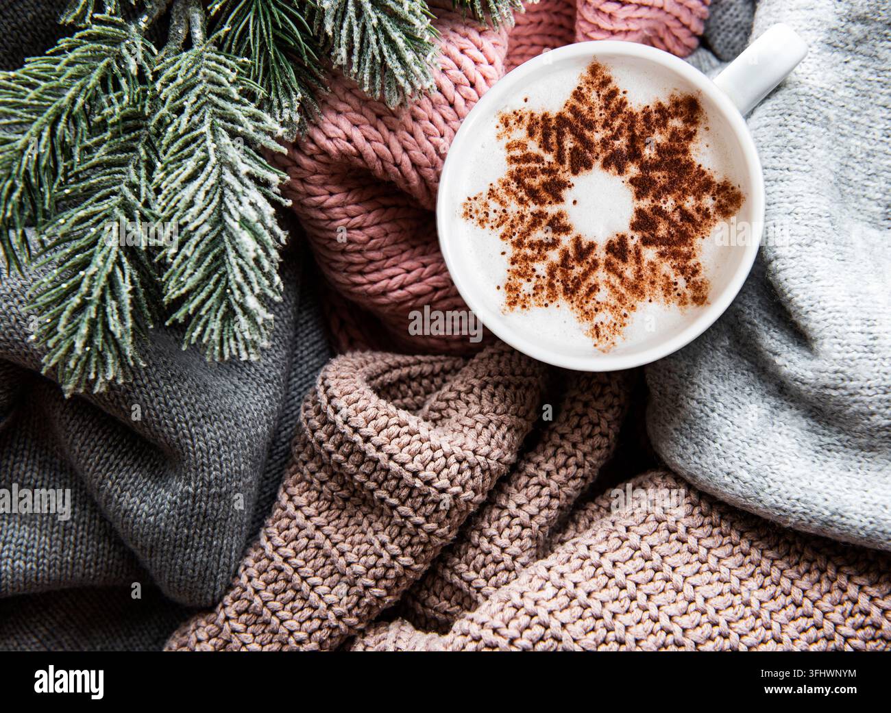 Coffee with a snowflake pattern on a warm knitted sweaters Stock Photo